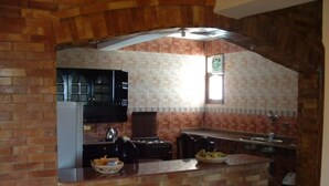 A kitchen with a herringbone brick pattern, a black microwave, and a window above the sink.