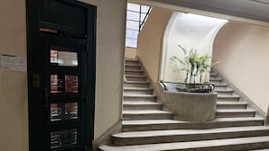 Eine Treppe mit einer gewölbten Wand und einer Tür mit einem Metallgitter.