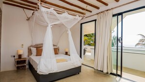 Ein Schlafzimmer mit Bett, Nachttischen und Blick ins Freie.