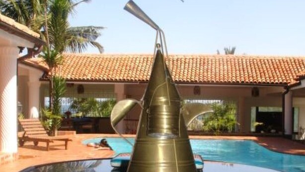 Zona piscina con una struttura metallica decorativa e diverse tazze.