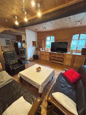 Uma sala de estar aconchegante com lareira, móveis de couro, televisão e armários de madeira.