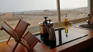 Cozinha com vista para a praia e paisagem desértica.