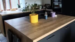 A modern kitchen with a wooden island, black cabinets, and a yellow pot on the countertop. - Country house with jacuzzi and pets allowed (Saint-Joire)