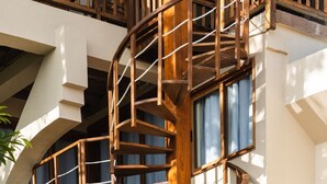 Una escalera en espiral con barandillas de madera y una pared exterior blanca.