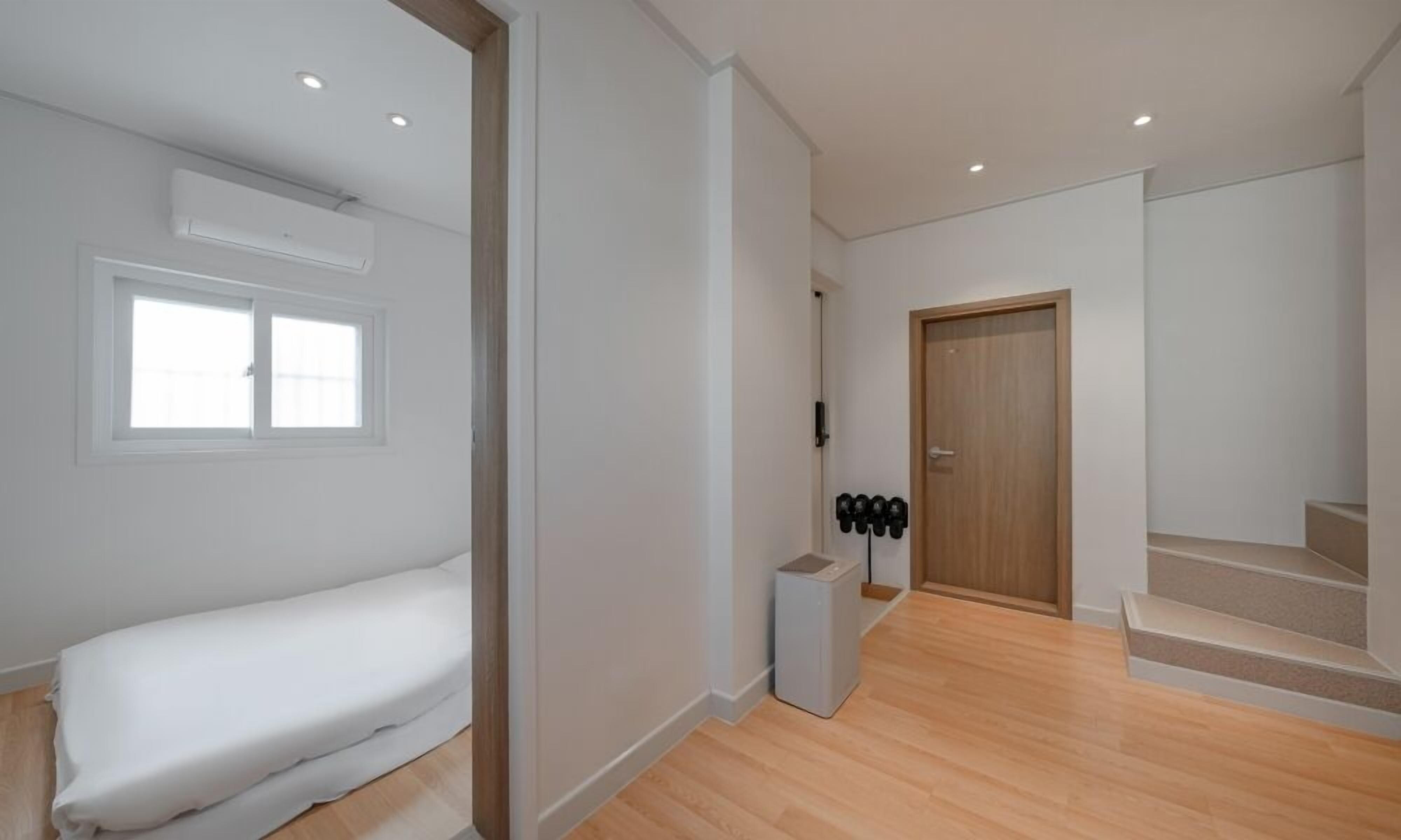 Ein modernes Interieur mit einem Bett, einer Treppe und einer Tür.