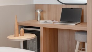A modern room with a wooden desk, a laptop, a lamp, and a small round table with two wooden objects. - H Avenue Hotel Andong Culture Street (Andong)