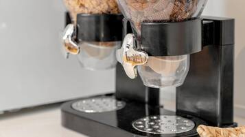 A coffee machine with two dispensers, a black base, and a stainless steel plate.
