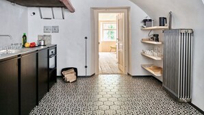 A compact kitchen with a tiled floor, a built-in oven, and a radiator. - Hofstätte 37 by Interhome (Vaduz)