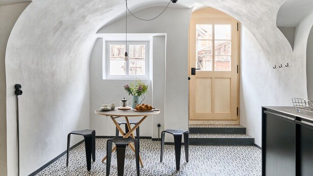 A room with a hexagonal tile floor, a round table with chairs, a window with curtains, and a door leading outside. - Hofstätte 37 by Interhome (Vaduz)