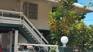 Un edificio de dos pisos con una escalera que lleva a un balcón.
