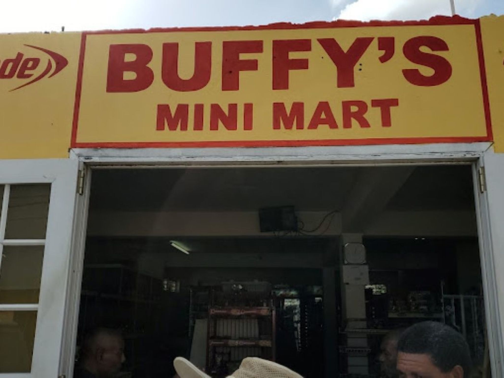 The entrance to a Buffy's Mini Mart with a yellow sign and a white door.