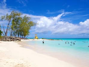 A beach with clear turquoise water, a lifeguard tower, and trees along the shore. - Gelassenes "Island Escape" mit Meerblick by Interhome (Christ Church)