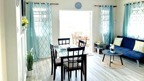 A living room with a dining area, a sofa, and a coffee table. - "Island Getaway Apt" mit Meerblick by Interhome (Christ Church)