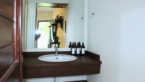A bathroom with a white sink, dark brown countertop, and a mirror above it. - Casa ampla com jardim e 3 suítes em Novo Airão (Novo Airão)