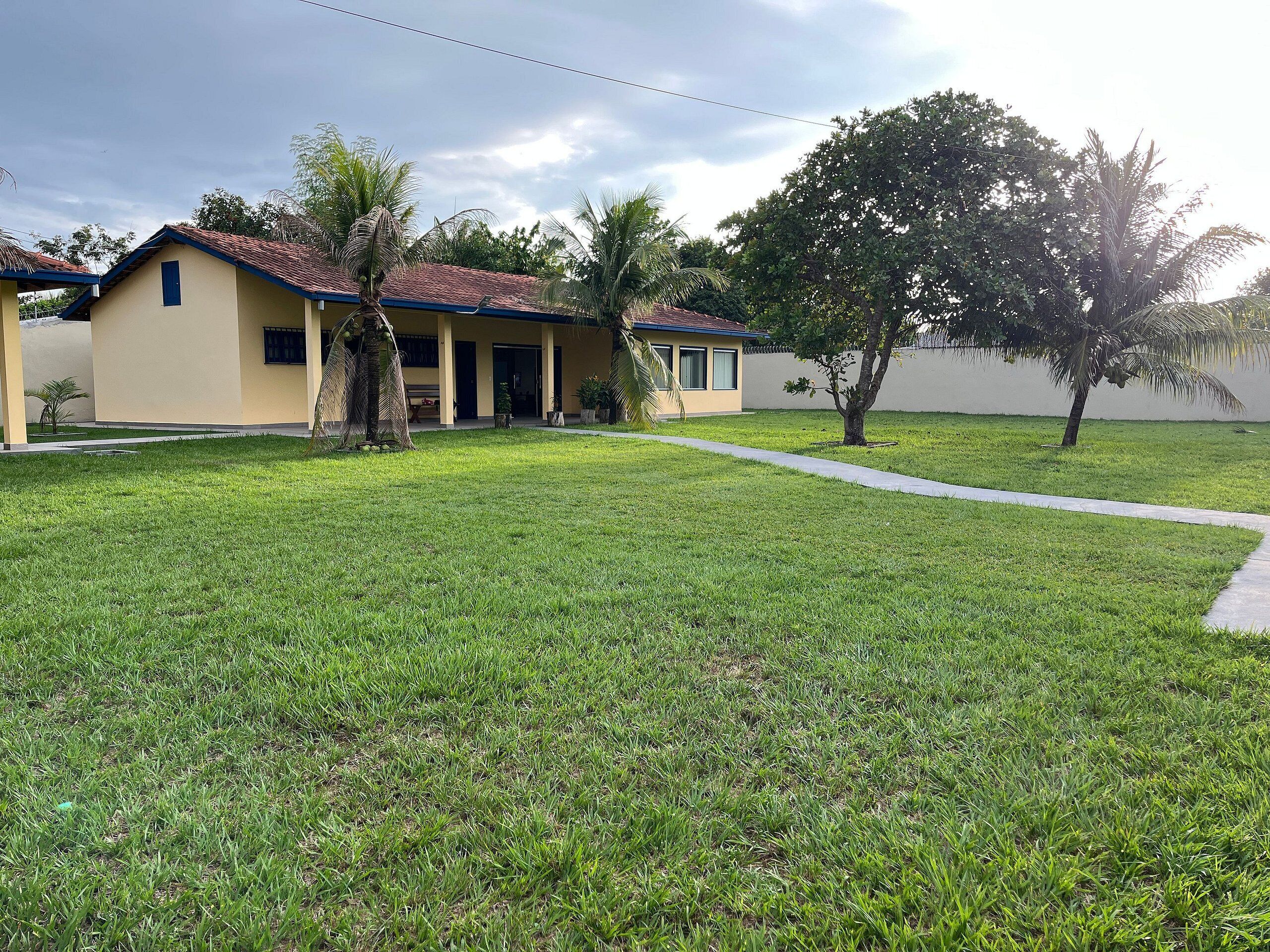 A building with a red-tiled roof, a covered porch, and a well-maintained lawn.