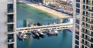 A marina with boats docked, a beach, and high-rise buildings. - LUX The Beach Isle View Suite 2 (Dubai)