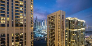 Un immeuble de grande hauteur doté de nombreux balcons, avec une marina en arrière-plan.