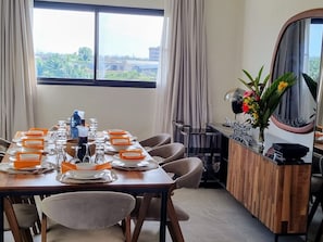 A dining area with a table set for a meal, chairs, a mirror, and a view of greenery outside. - Villa Bolati, mit Pool, Jacuzzi, Aussicht und Garten by Interhome (Yaou)