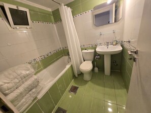 Um banheiro com banheira, vaso sanitário e pia.