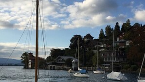 Ein Hafen mit mehreren Segelbooten, umgeben von Häusern und Bäumen.
