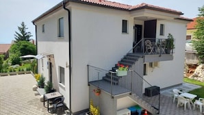 A two-story house with a balcony, a staircase, and outdoor seating. - Villa Madlen - Sea View Apartment 1 (Opatija)