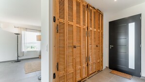 A room with a large wooden closet, a black door, and a floor lamp. - Villa 'Lo Ginest' with Mountain View, Wi-Fi, and Air Conditioning (Villedieu)