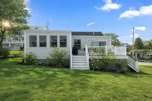 A small, single-story house with a front porch and a staircase leading to the entrance. - Life on Deck - Spacious Coastal Home & Easy Beach Access (Gloucester)
