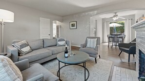 Ein Wohnzimmer mit einer Couch, einem Sessel, einem runden Couchtisch und einem Kamin.