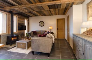 Ein gemütliches Wohnzimmer mit Kamin, Sofa und Fernseher.