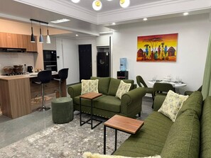 Ein modernes Wohnzimmer mit einem grünen Sofagarnitur, einem kleinen Holztisch und einem Bild an der Wand.