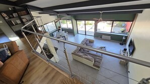 Un interno moderno con una scala, un divano, un tavolino da caffè e una libreria.