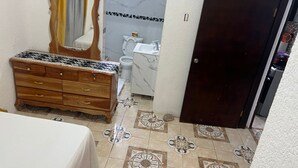 A bathroom with a wooden dresser, a mirror, a toilet, and a sink. - Peaceful 1-bedroom apartment with AC in charming Ocho Rios (Ocho Rios)