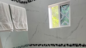A bathroom with a shower, toilet, and sink. - Peaceful 1-bedroom apartment with AC in charming Ocho Rios (Ocho Rios)