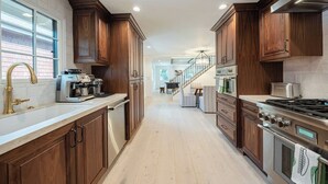 Eine moderne Küche mit Holzausbau, Edelstahlgeräten und einer zentralen Kochinsel.
