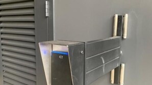 A metallic, rectangular device mounted on a grey wall, with a vent on the left and two cylindrical objects on the right. - 2 Bedrooms Apprtmt Plus Underground Parking in CBD (Christchurch)