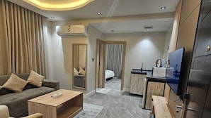 A modern hotel room with a living area, a separate bedroom, and a kitchenette. - dormira serviced apartments (Riyadh)
