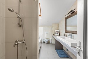 Un baño moderno con ducha, inodoro y lavamanos.