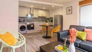 A compact living space with a kitchen, dining area, and seating. - Central 1-bed Apartment With Free Parking & Wifi (Leicester)
