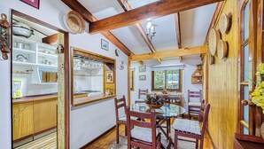 Un comedor acogedor con vigas de madera, una mesa redonda y sillas.