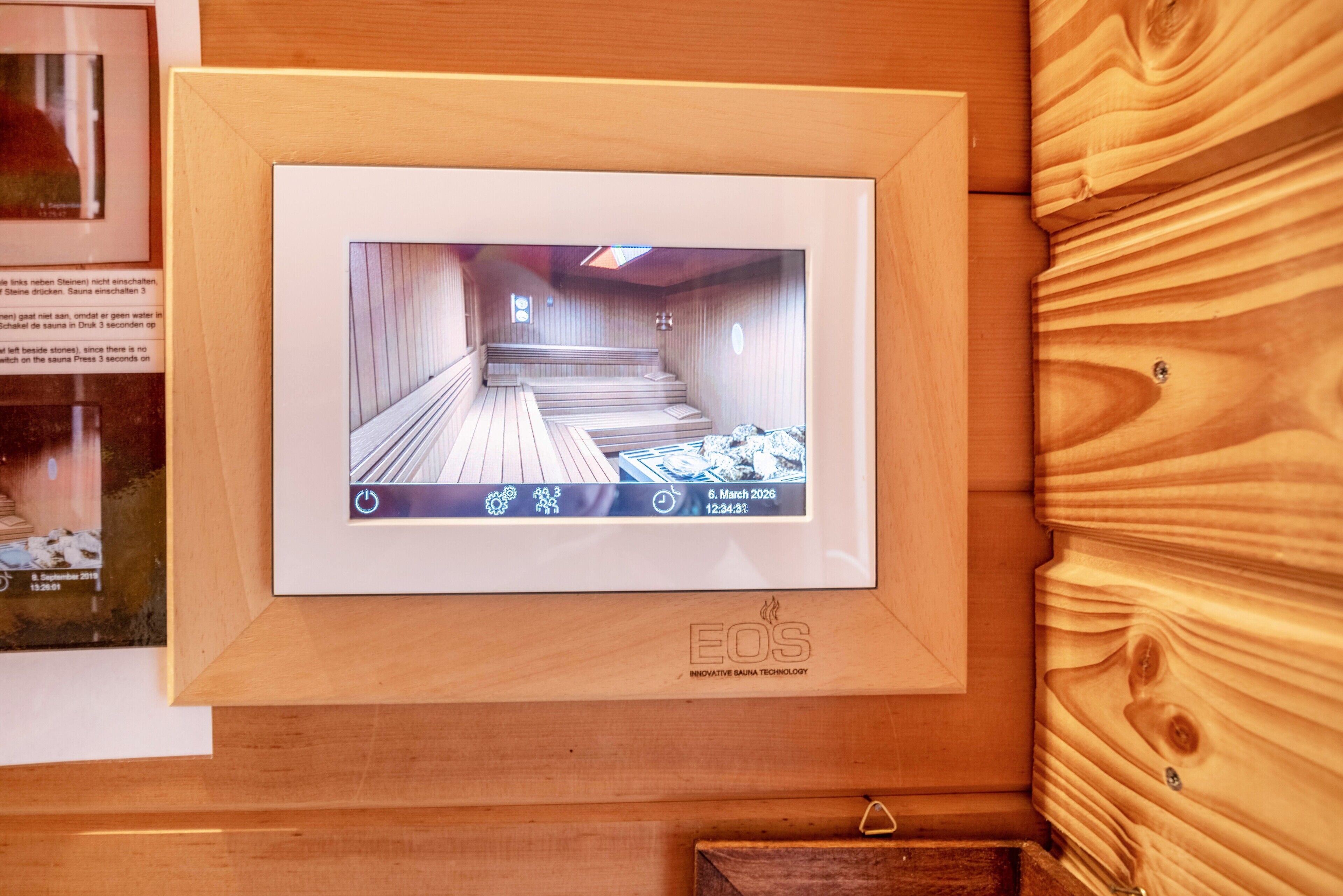A framed video display of a sauna room with wooden walls and benches.