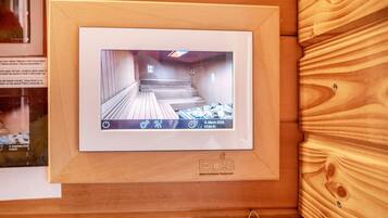 A framed video display of a sauna room with wooden walls and benches.