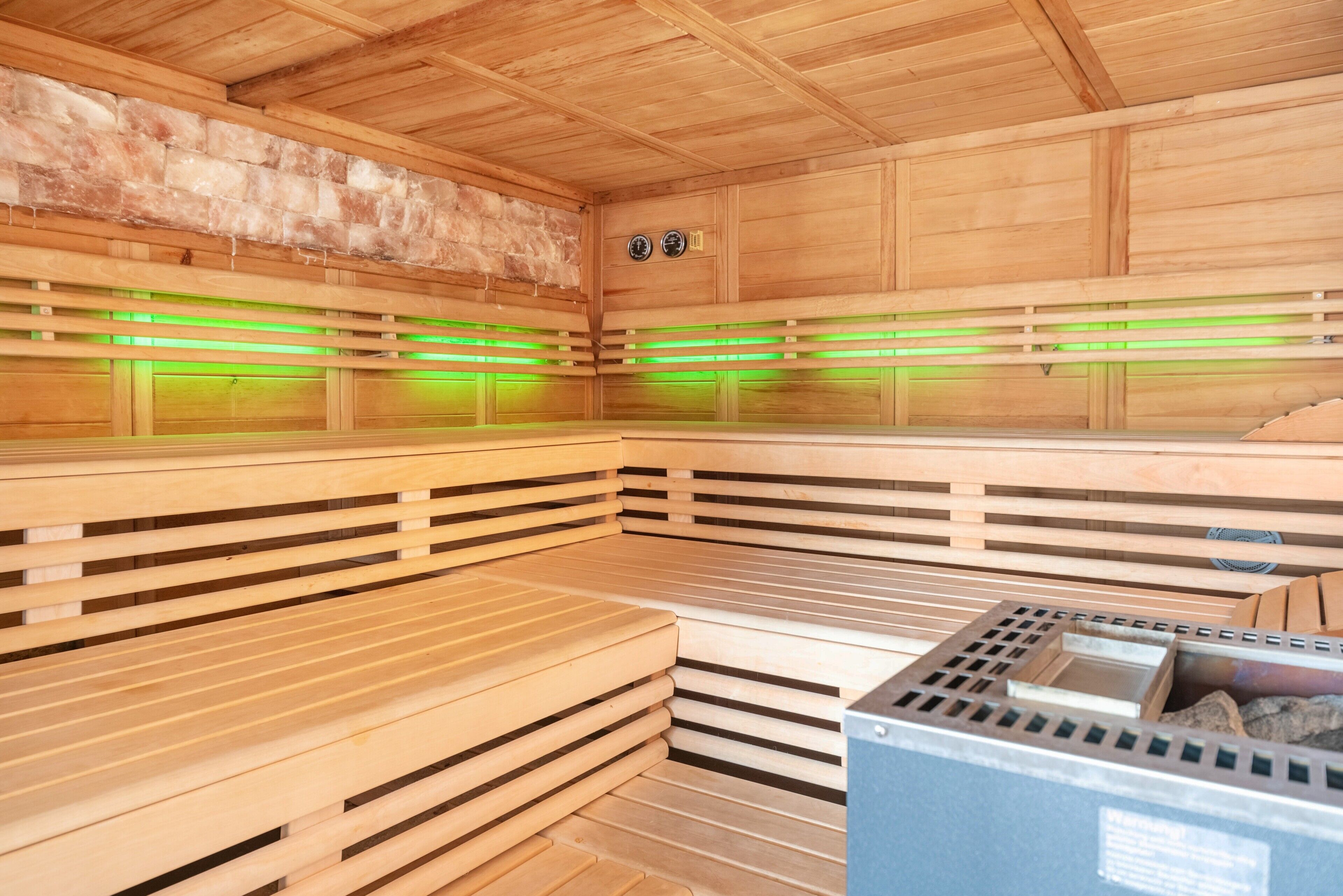 En sauna med træbænke og grønt lys.