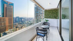 Een balkon met uitzicht op een stadsgezicht, met moderne gebouwen en een heldere lucht.