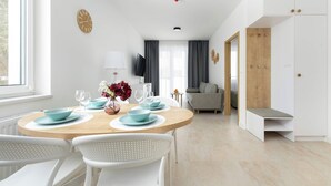 Un comedor moderno con una mesa redonda, sillas blancas y platos azules.