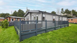 A modern mobile home with a fenced yard and a well-maintained lawn. - Host & Stay | What The Duck (Pocklington)