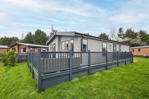 A modern mobile home with a fenced yard and a well-maintained lawn. - Host & Stay | What The Duck (Pocklington)