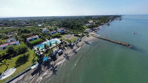 An aerial view of a coastal resort with a swimming pool, beach, and ocean. - Ancla del galeon 7 (Tolú)