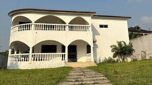 A two-story building with a central courtyard, arched balconies, and a paved entrance. - Private rooms in a Villa - Abidjan, Ivory Coast (Abidjan)