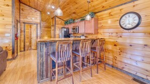 Ein Holzhütten-Interieur mit Barbereich, Holzwänden und einer Wanduhr.