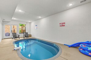 An indoor swimming pool with a no diving sign, a pool heater, and a pool noodle on the right side. - Relaxing 5BD POOL Lodge| Theater + Hot Tub + Games (Sevierville)